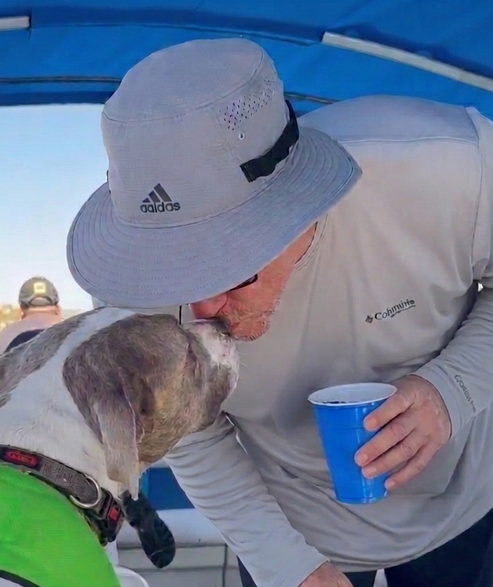 Bill greeting a dog while boating
